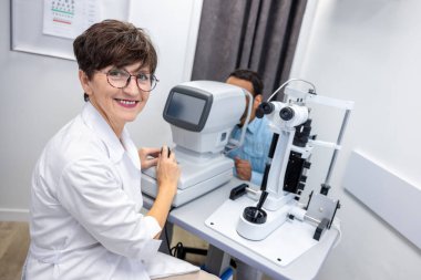 Ophtalmology. Optometrist in white scubs near refractometer