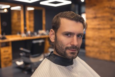 At the barbers. Young man choosing the hairstyle at the barbershop