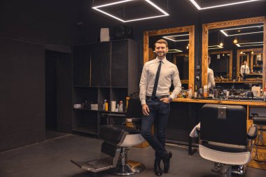 Elegant man. Good-looking confident businessman in a barbershop