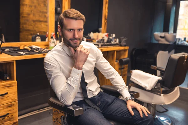 Elegant man. Good-looking confident businessman in a barbershop