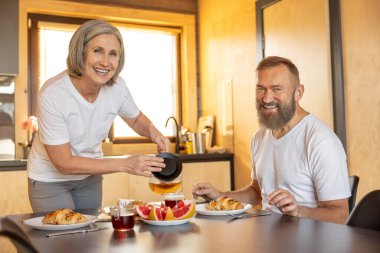 Breakfast time. Happy couple having breakfast and feeling comfortable