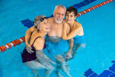 Healthy lifestyle. Group of seniors at the swimming pool looking happy and enjoyed