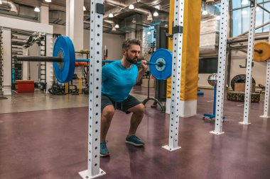 Bar zili egzersizi. Bir bar ziliyle çalışırken atlet kararlı ve ciddi görünüyor