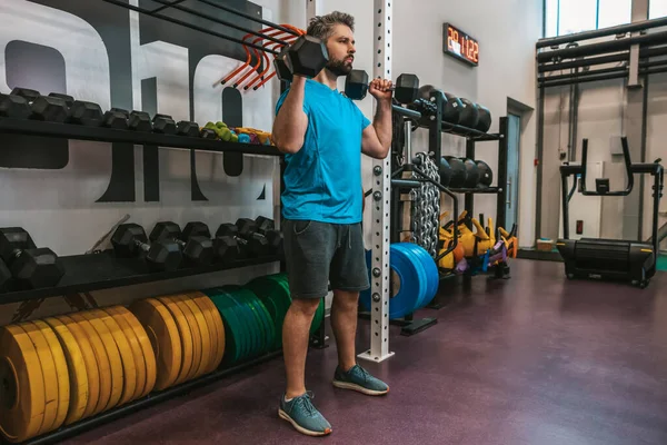 Ağır toplar. Spor salonunda ağır toplarla çalışan bir sporcu.