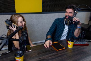Stüdyoda. Radyo DJ stüdyo konuğuyla konuşuyor ve memnun görünüyor.
