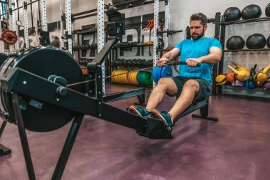 Çekirdek egzersizi. Spor salonundaki sporcu ağırlık kaldırıyor ve özünde çalışıyor.