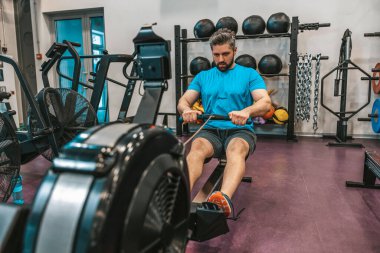 Çekirdek egzersizi. Spor salonundaki sporcu ağırlık kaldırıyor ve özünde çalışıyor.