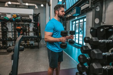 Sporcu. Spor kulübünde dambıllarla çalışan adam.