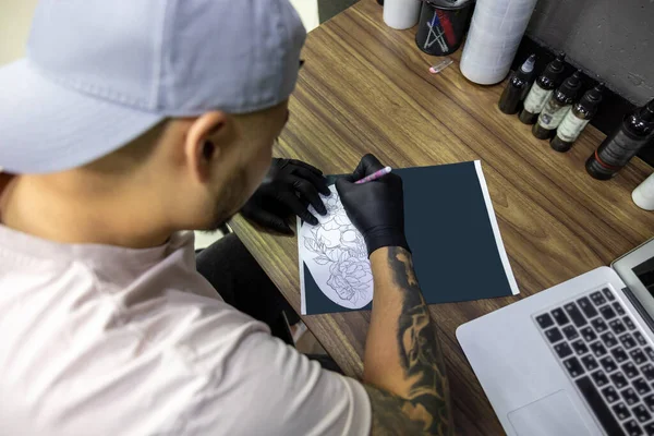 在纹身沙龙里纹身沙龙的纹身大师和冰棍一起工作 — 图库照片