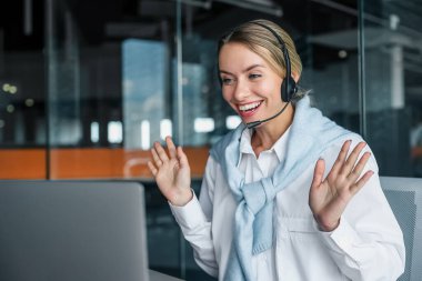 Görüntülü arama. Kulaklık takan genç bir bayan müdürün görüntülü konuşması var.