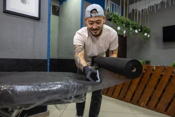 stock image In the tattoo salon. Asian tattoo master preparing couch for tattoo session