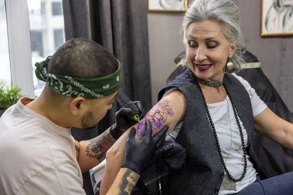 纹身大师 男纹身大师在美容院和客人一起工作 — 图库照片