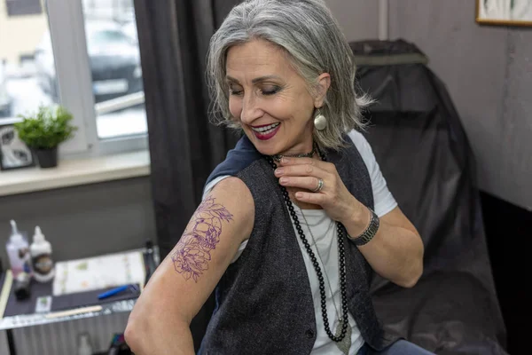 Tatueringssalongen Långhårig Kvinna Tittar Sin Nya Tatuering — Stockfoto