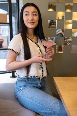 Kahve masasındaki bankta oturan hoş, siyah saçlı, hoş bir kadın.