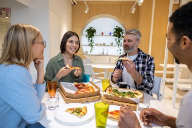 Öğle yemeği vakti. Arkadaşlar öğle yemeğinde eğleniyorlar ve pizzanın tadını çıkarıyorlar.