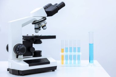 Renkli sıvı ve mikroskop, mikrobiyolog ya da kimyagerin çalıştığı farklı laboratuvar camları..