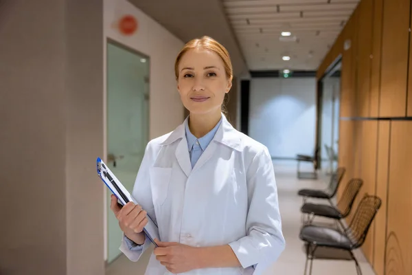 Ελκυστική Ξανθιά Νεαρή Γυναίκα Γιατρός Στέκεται Στο Διάδρομο Του Νοσοκομείου — Φωτογραφία Αρχείου