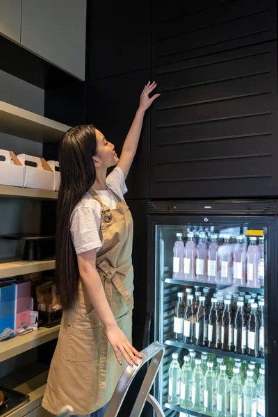 Trabajador Cafetería Enfocado Pie Escalera Tocando Pared Sobre Gabinete Exhibición — Foto de Stock
