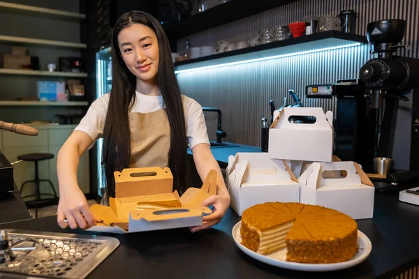 Trabajador Cafetería Pie Mostrador Mientras Empaca Una Rebanada Pastel Caja — Foto de Stock