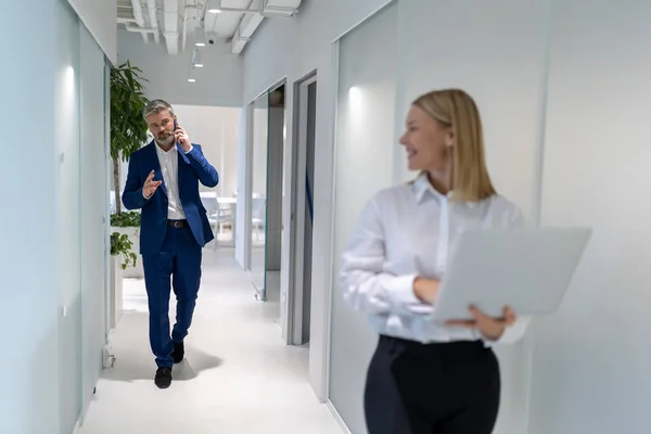 Komoly Vállalkozó Telefonál Miközben Üzleti Partnere Felé Sétál Irodai Folyosón — Stock Fotó