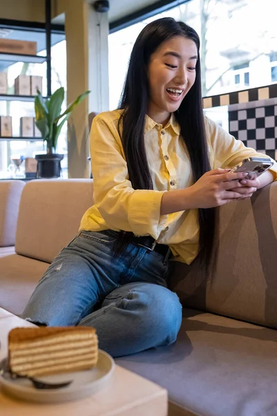 Mujer Joven Emocionada Viendo Algo Teléfono Inteligente Mientras Sienta Sofá — Foto de Stock