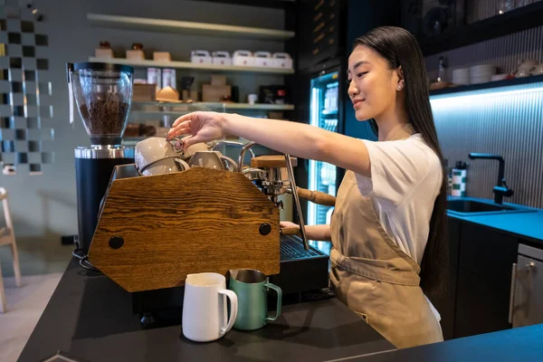 Smiling Pleased Young Female Cafe Worker Reaching Clean Ceramic Cup — Stock Photo, Image