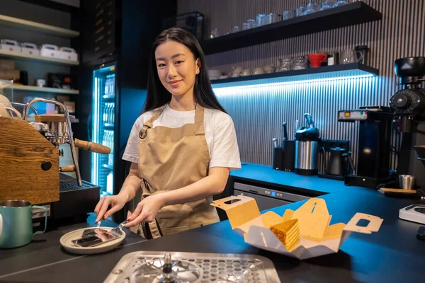 Agradable Joven Asiático Trabajador Cafetería Empacando Una Rebanada Sabroso Pastel — Foto de Stock