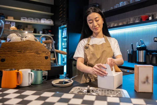 Ηρεμία Επικεντρώθηκε Χαριτωμένο Νεαρή Ασιατική Γυναίκα Υπάλληλος Καφετέριας Συσκευασίας Ένα — Φωτογραφία Αρχείου