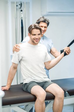 Uzuv hipergenişlemesi. Hastalarla birlikte çalışan fizyoterapist uzuvlarını aşırı uzatıyor.