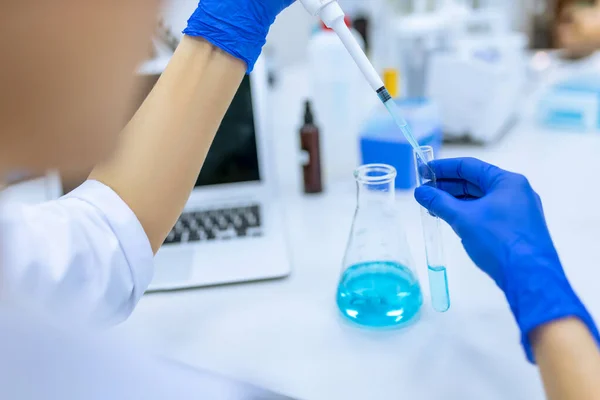 Oigenkännlig Forskare Bär Blå Gummihandskar Undersöker Vätska Provrör Laboratorium — Stockfoto