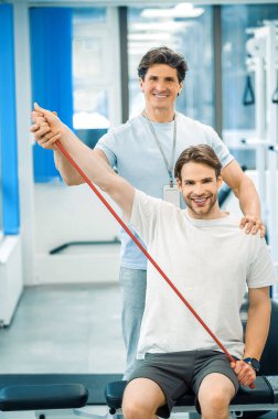 Fizik tedavi. Genç bir adam bir doktorla fizik tedavi seansı yapıyor.