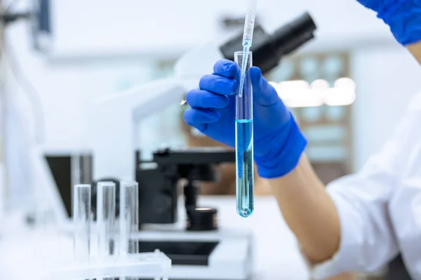 실험실에서 장비를 파란색 장갑을 액체와 실험을 무명의 연구원 — 스톡 사진
