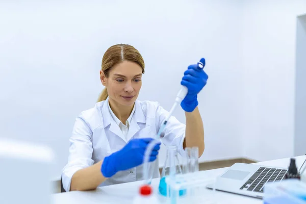 在科学的化学实验室里 戴着防护手套 带着长笛 把液态物质扔进试管 这很吸引女性科学家的注意 — 图库照片