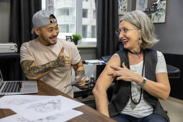 Тату Салоне Взрослая Женщина Выбирает Место Татуировки Татуировщиком — стоковое фото