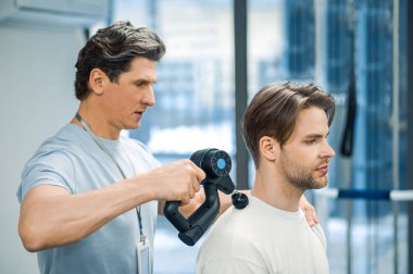 Fizyoterapi. Fizyoterapist bir hastayla tedavi seansı yapıyor.