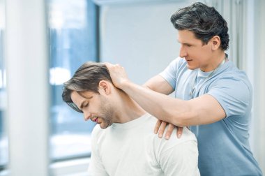 Boyun rehabilitasyonu. Hasta boynu üzerinde çalışan fizyoterapist.