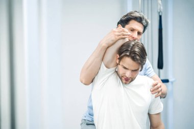 Boyun rehabilitasyonu. Hasta boynu üzerinde çalışan fizyoterapist.