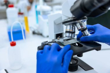 Modern laboratuarda mikroskop ve genetik araştırmalarla çalışan tanınmayan doktor, öğrenci ya da teknisyen..