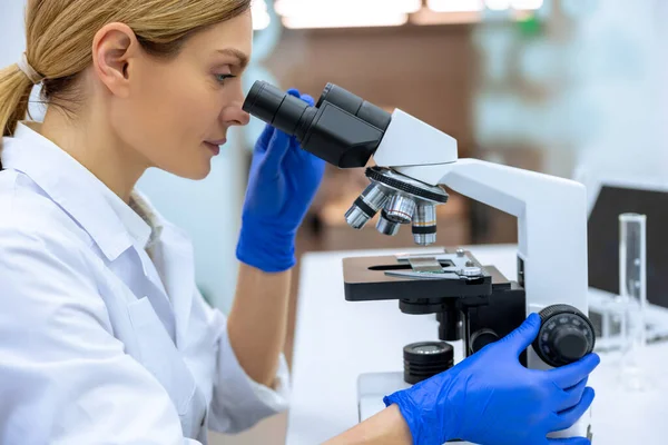 在实验室工作 从事微生物学研究的高加索女科学家 利用实验室工具显微镜 生物技术 细菌学 病毒学和保健 — 图库照片