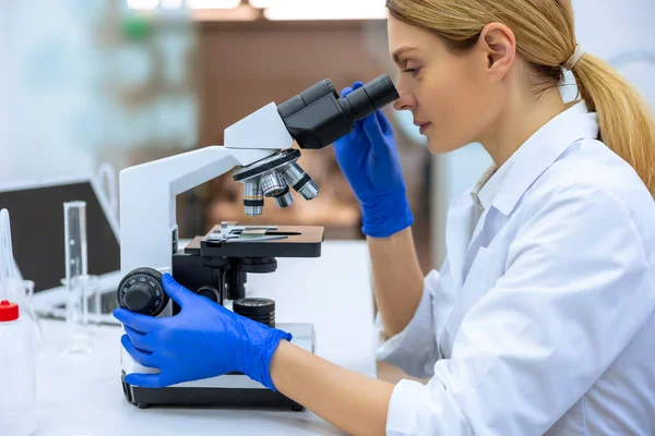 在生物科学实验室工作的保健研究人员 利用显微镜 分析实验室中的病毒信息 — 图库照片
