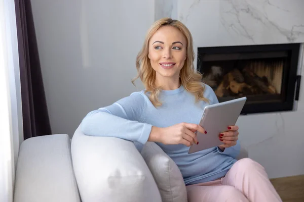 Zâmbind Femeie Blondă Fericită Așezată Canapeaua Confortabilă Tableta Digitală Uitându — Fotografie, imagine de stoc