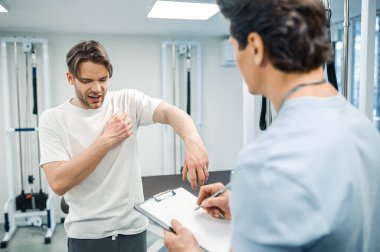 Fizik tedavi. Erkek hasta rehabilitasyon merkezinde fizik tedavi görüyor.