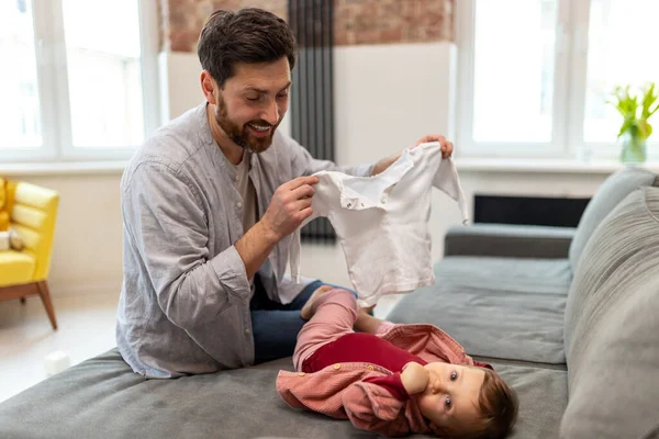 Evde Yeni Yürümeye Başlayan Kızı Olan Baba Bebeğinin Kıyafetlerini Değiştiriyor — Stok fotoğraf