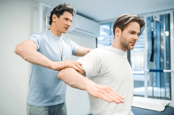 Recovery Exercising Male Physical Therapist Working Patient Looking Invloved — Stock Photo, Image