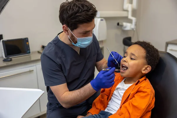 歯医者だ 男性医師でマスクで彼の患者をチェック — ストック写真
