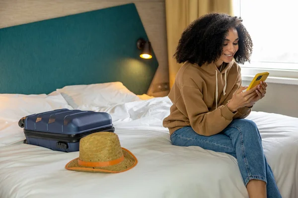 年轻的女人 黑头发的年轻女人 手里拿着手机躺在床上 — 图库照片