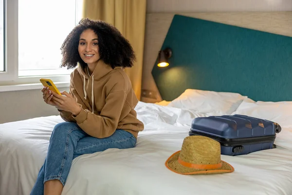年轻的女人 黑头发的年轻女人 手里拿着手机躺在床上 — 图库照片