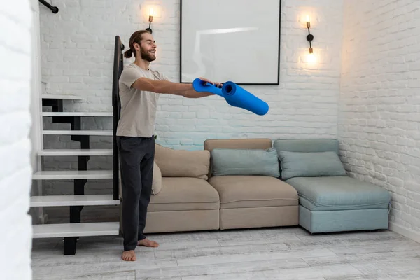 Atletische Man Ontrollen Yoga Mat Tijdens Voorbereiding Oefenen Thuis — Stockfoto
