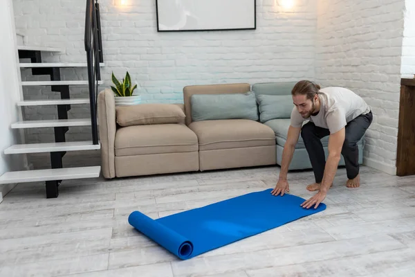 Yetişkin Yakışıklı Adam Yoga Minderini Açıyor Evde Meditasyon Yapmaya Hazırlanıyor — Stok fotoğraf