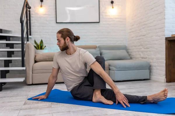 Evde Yoga Yapan Genç Bir Adam Yoga Minderinde Vücut Esnetiyor — Stok fotoğraf